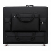 Black Massage Table Carry Case with wheels; wheeled massage table bag for folding tables; heavy-duty nylon massage table carry case; black massage table case with four front pockets; massage table carry case with shoulder sling; wheeled massage table bag with storage pockets; portable massage table case with multi-directional wheels; massage table travel case for tables up to 30 inches wide